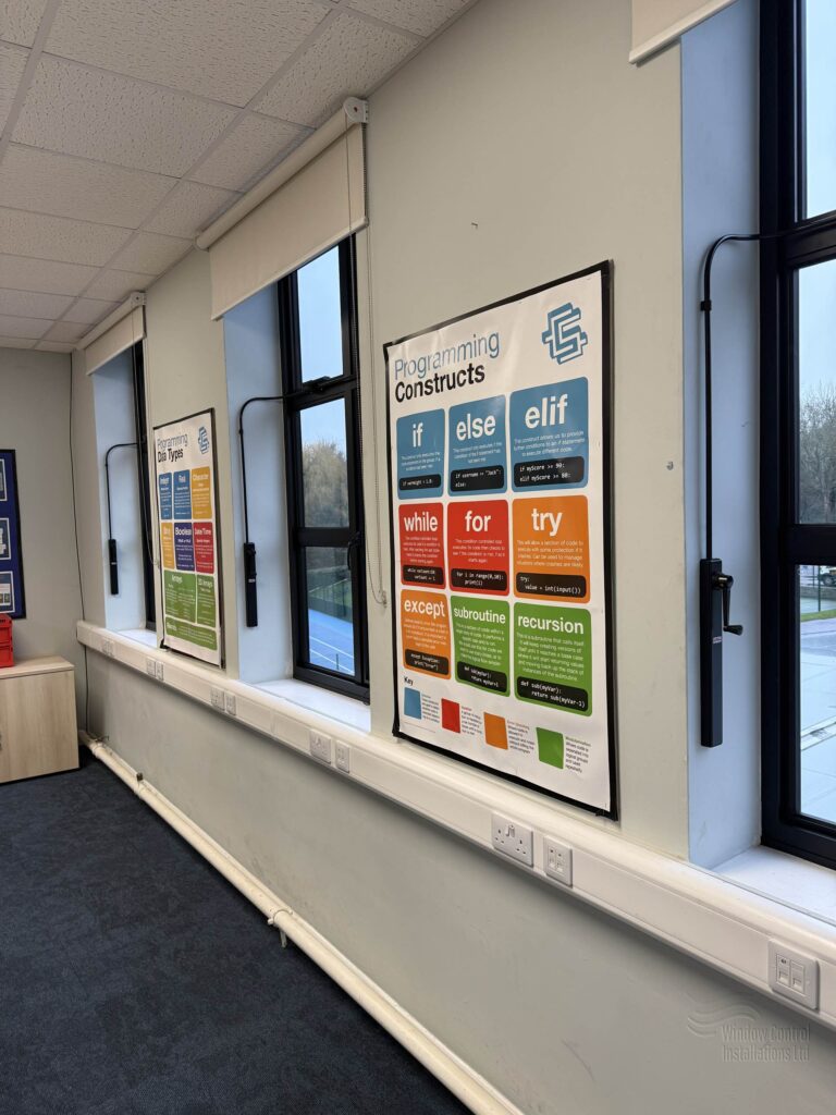 High-level manual window openers mounted on a classroom wall to operate inaccessible windows.