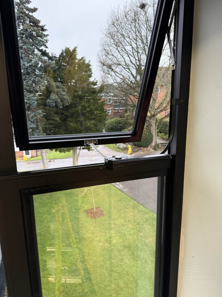 Detail showing the opening stroke of a manual window ventilation system in the open position.