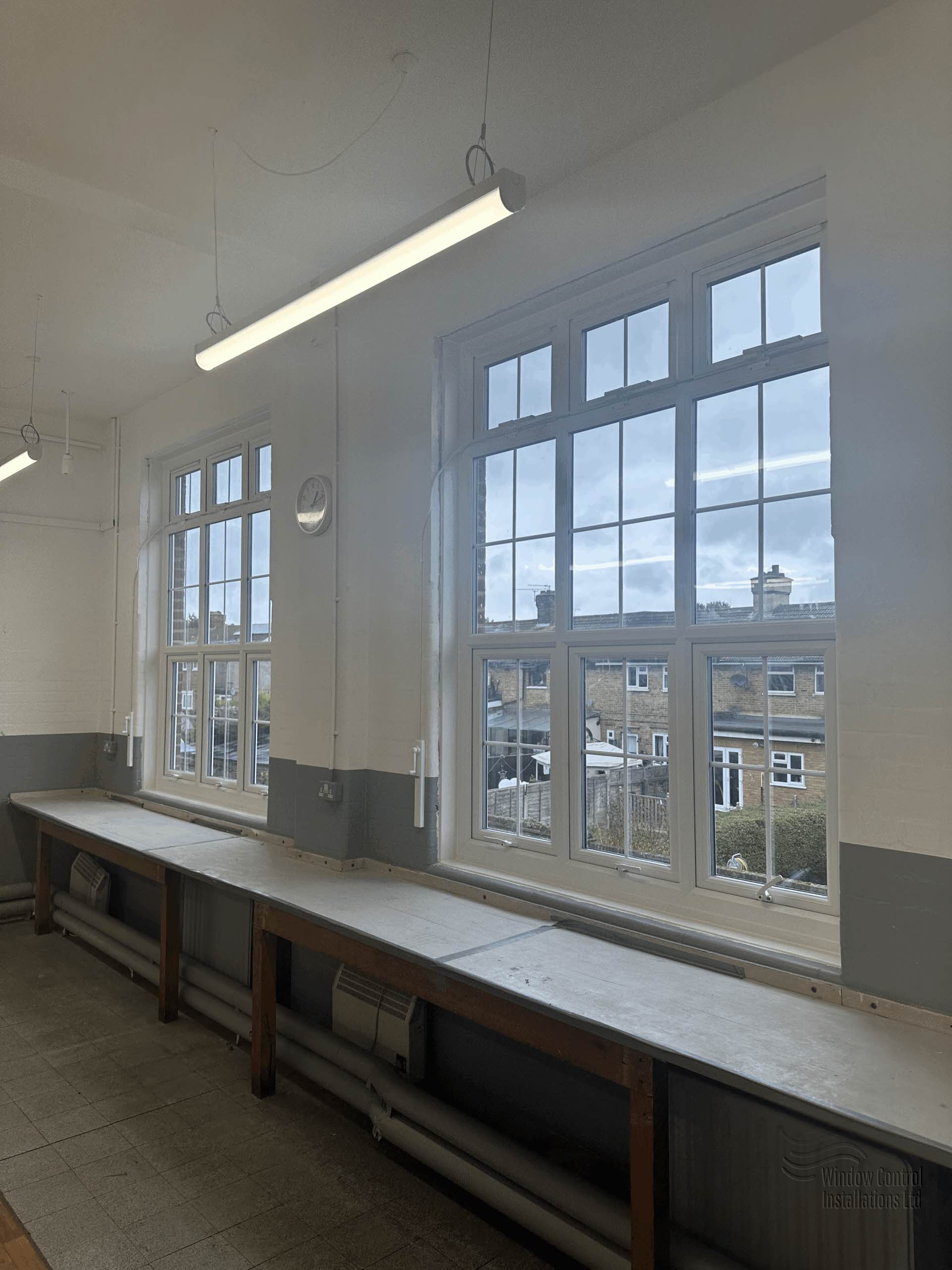 Interior of a school workshop featuring high-level white windows operated by a Teleflex manual window controls