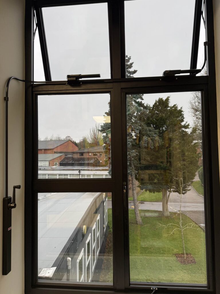 Twin Clearline 250 chain operators in black finish installed on a top-hung window.
